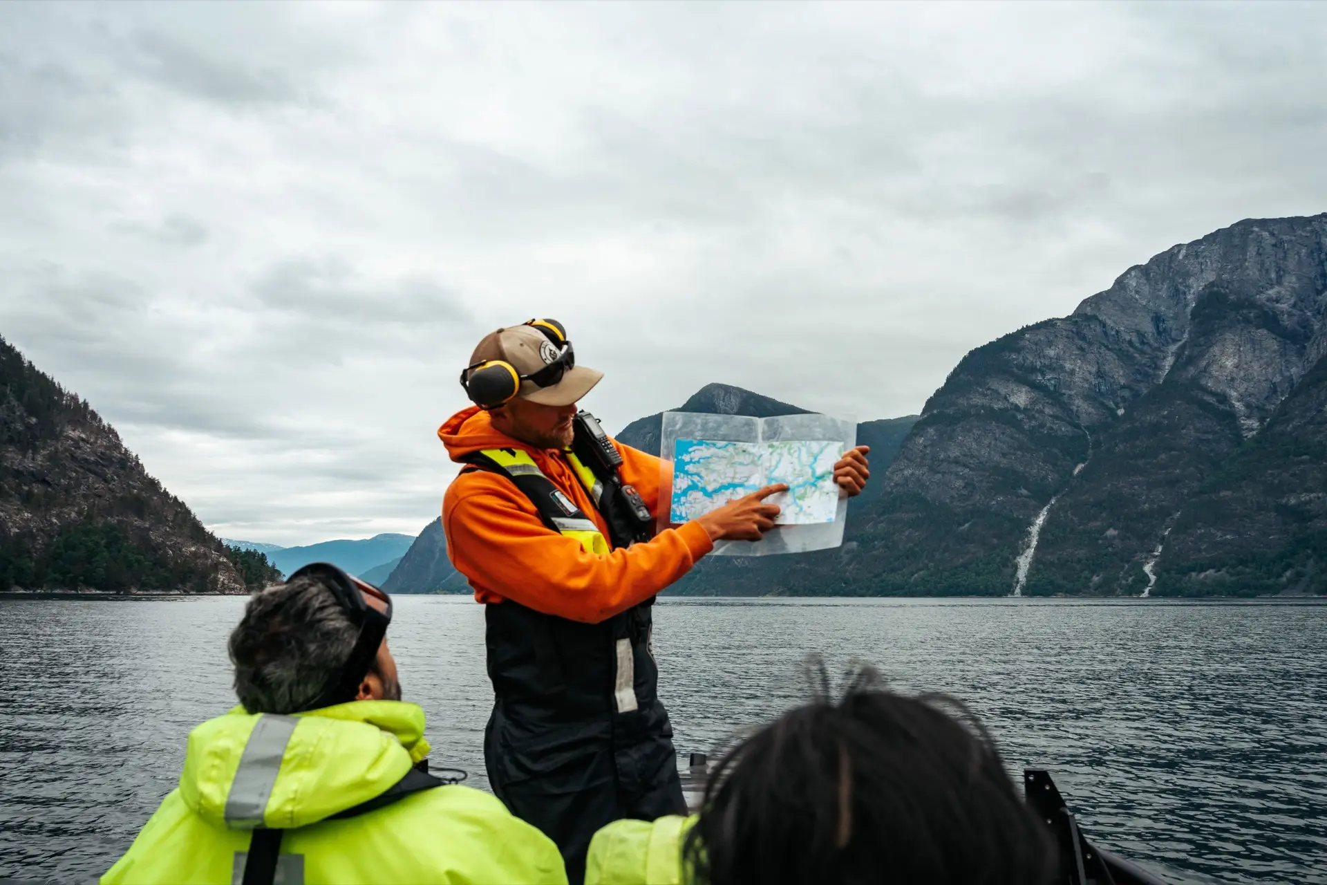 Tour guide showing map to guests on fjord boat tour